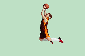 Image showing Young caucasian female basketball player against mint colored studio background