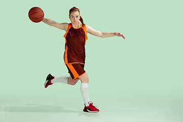 Image showing Young caucasian female basketball player against mint colored studio background