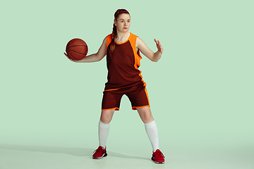 Image showing Young caucasian female basketball player against mint colored studio background