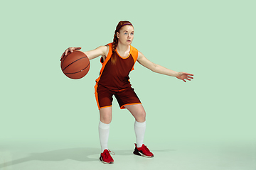 Image showing Young caucasian female basketball player against mint colored studio background