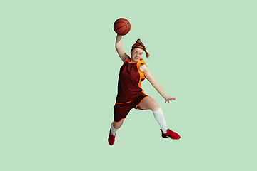 Image showing Young caucasian female basketball player against mint colored studio background