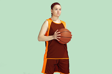 Image showing Young caucasian female basketball player against mint colored studio background