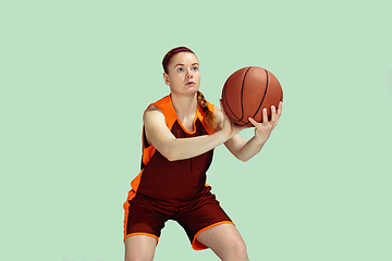 Image showing Young caucasian female basketball player against mint colored studio background