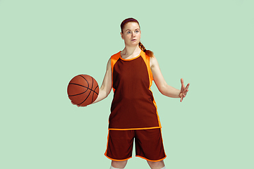 Image showing Young caucasian female basketball player against mint colored studio background