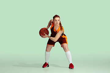 Image showing Young caucasian female basketball player against mint colored studio background