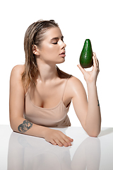 Image showing Pure. Beautiful young woman with fresh avocado over white background. Cosmetics and makeup, natural and eco treatment, skin care.