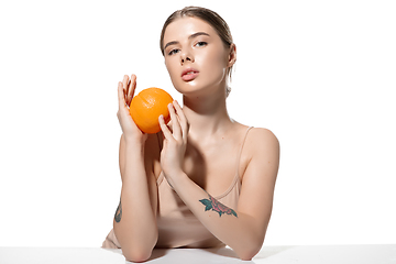 Image showing Dreams. Beautiful young woman with orange over white background. Cosmetics and makeup, natural and eco treatment, skin care.