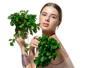 Image showing Healthy. Beautiful young woman with green leaves on her face over white background. Cosmetics and makeup, natural and eco treatment, skin care