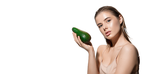 Image showing Fashionable. Beautiful young woman with fresh avocado over white background. Cosmetics and makeup, natural and eco treatment, skin care. Flyer with copyspace.