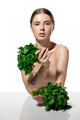 Image showing Healthy. Beautiful young woman with green leaves on her face over white background. Cosmetics and makeup, natural and eco treatment, skin care