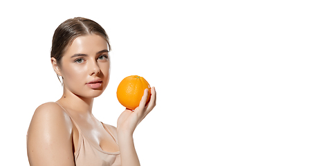 Image showing Shine. Beautiful young woman with orange over white background. Cosmetics and makeup, natural and eco treatment, skin care. Flyer.