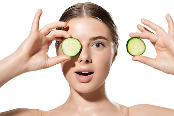 Image showing Freshness. Beautiful young woman with fresh cucumber on her face over white background. Cosmetics and makeup, natural and eco treatment, skin care.