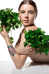 Image showing Healthy. Beautiful young woman with green leaves on her face over white background. Cosmetics and makeup, natural and eco treatment, skin care