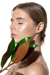 Image showing Tender. Beautiful young woman with green leaves on her face over white background. Cosmetics and makeup, natural and eco treatment, skin care