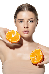Image showing Juicy. Beautiful young woman with halfs of orange over white background. Cosmetics and makeup, natural and eco treatment, skin care.