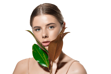 Image showing Protection. Beautiful young woman with green leaves on her face over white background. Cosmetics and makeup, natural and eco treatment, skin care