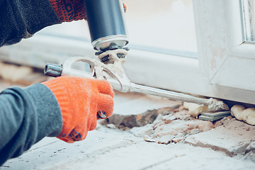 Image showing Close up of hands of repairman, professional builder working indoors, installs window