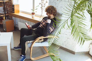 Image showing Portrait of millenial boy using retro toys, meeting things from the past and having fun, nostalgic, expressive playing tetris