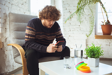 Image showing Portrait of millenial boy using retro toys, meeting things from the past and having fun, nostalgic, expressive playing tetris