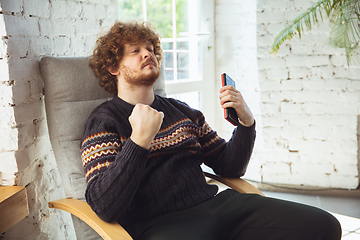 Image showing Portrait of millenial boy using retro toys, meeting things from the past and having fun, nostalgic, expressive playing tetris