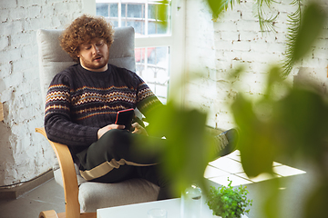 Image showing Portrait of millenial boy using retro toys, meeting things from the past and having fun, nostalgic, expressive playing tetris