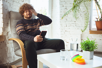 Image showing Portrait of millenial boy using retro toys, meeting things from the past and having fun, nostalgic, expressive playing tetris