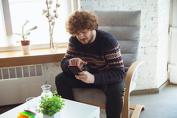 Image showing Portrait of millenial boy using retro toys, meeting things from the past and having fun, nostalgic, expressive playing tetris