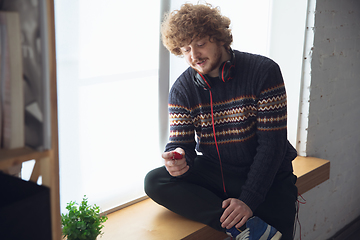 Image showing Portrait of millenial boy using retro toys, meeting things from the past and having fun, nostalgic, playing tamagotchi, virtual pet