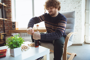 Image showing Portrait of millenial boy using retro toys, meeting things from the past and having fun, nostalgic, playing wooden constructor