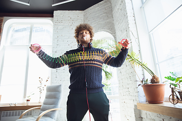 Image showing Portrait of millenial boy using retro toys, meeting things from the past and having fun, nostalgic, using rainbow spring toy