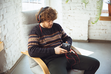 Image showing Portrait of millenial boy using retro toys, meeting things from the past and having fun, nostalgic, listen to music with cassette player