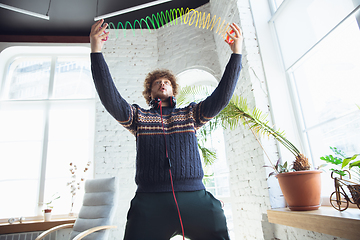 Image showing Portrait of millenial boy using retro toys, meeting things from the past and having fun, nostalgic, using rainbow spring toy