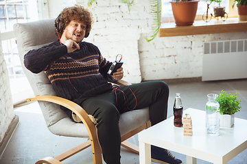 Image showing Portrait of millenial boy using retro toys, meeting things from the past and having fun, nostalgic, listen to music with cassette player