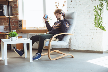 Image showing Portrait of millenial boy using retro toys, meeting things from the past and having fun, nostalgic, listen to music with cassette player