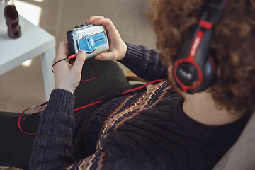 Image showing Portrait of millenial boy using retro toys, meeting things from the past and having fun, nostalgic, listen to music with cassette player