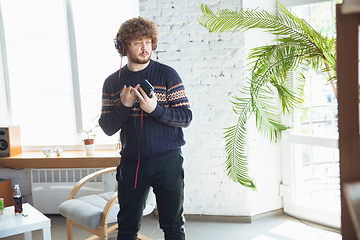 Image showing Portrait of millenial boy using retro toys, meeting things from the past and having fun, nostalgic, listen to music with cassette player