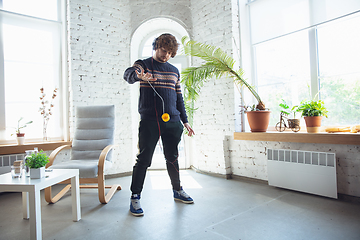 Image showing Portrait of millenial boy using retro toys, meeting things from the past and having fun, nostalgic, playing yo-yo