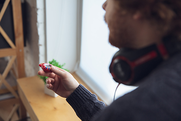 Image showing Portrait of millenial boy using retro toys, meeting things from the past and having fun, nostalgic, playing tamagotchi, virtual pet