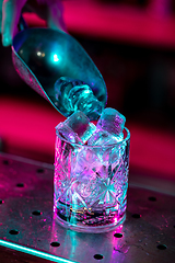 Image showing Close up of alcoholic cocktail, beverage, drink, glass full of ice in multicolored neon light