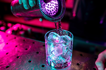 Image showing Close up of alcoholic cocktail, beverage, drink, glass full of ice in multicolored neon light