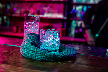 Image showing Close up of alcoholic cocktail, beverage, drink, glass full of ice in multicolored neon light