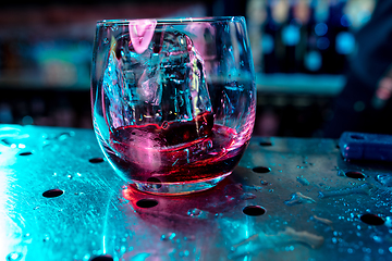 Image showing Close up of alcoholic cocktail, beverage, drink in multicolored neon light