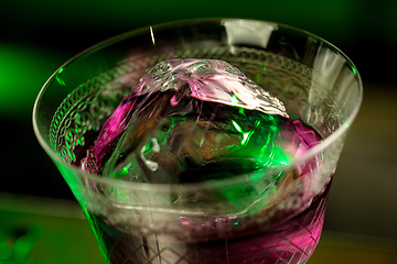 Image showing Close up of alcoholic cocktail, beverage, drink in multicolored neon light