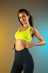 Image showing Fashion portrait of young fit and sportive woman on gradient background. Perfect body ready for summertime.