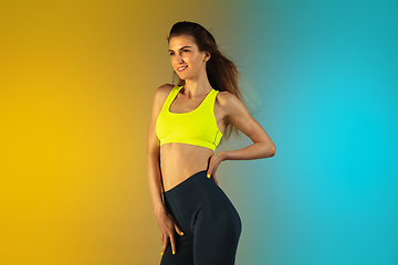 Image showing Fashion portrait of young fit and sportive woman on gradient background. Perfect body ready for summertime.