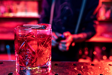 Image showing Close up of alcoholic cocktail, beverage, drink, prepared by professional barman in multicolored neon light