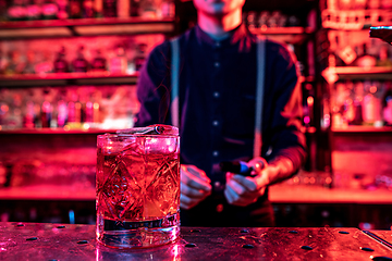 Image showing Close up of alcoholic cocktail, beverage, drink, glass full of ice in multicolored neon light
