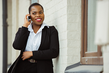 Image showing African-american businesswoman in office attire smiling, looks confident and happy, successful