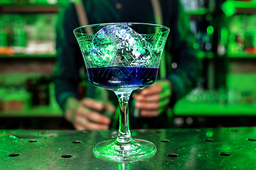 Image showing Close up of alcoholic cocktail, beverage, drink, prepared by professional barman in multicolored neon light