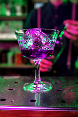 Image showing Close up of alcoholic cocktail, beverage, drink, prepared by professional barman in multicolored neon light